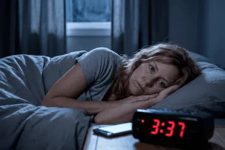 Hero · Frau ~50 nachts wach im Bett, Wecker zeigt kurz nach 3 Uhr, ruhige gedämpfte Nachtstimmung